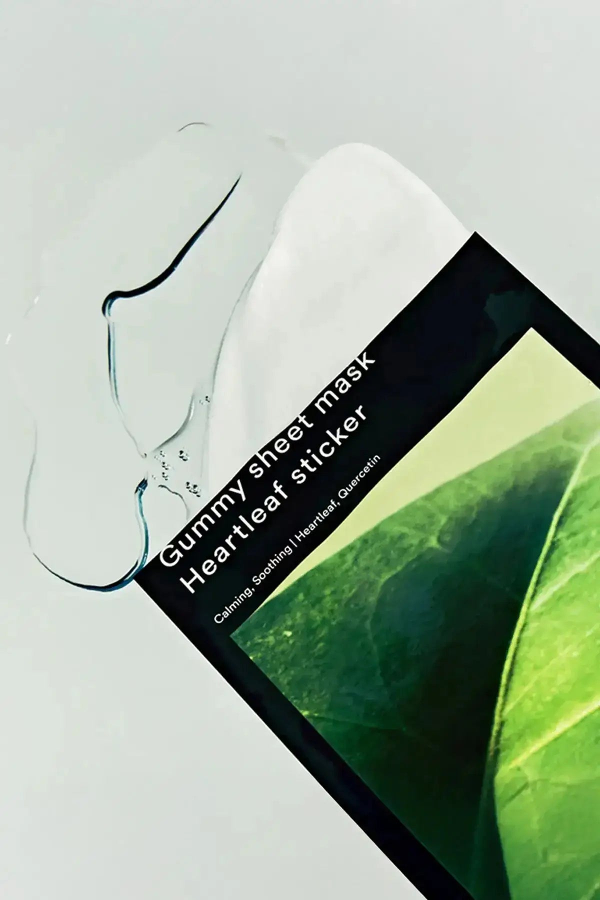 Angled close-up of Abib Heartleaf Sticker gummy sheet mask packaging with clear gel texture beside the pack, soothing mask for sensitive skin