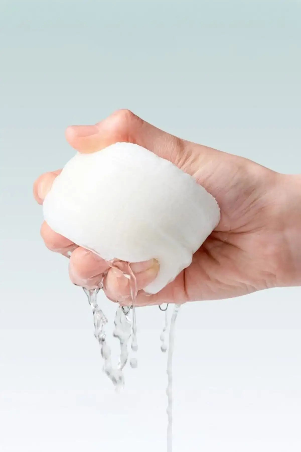 Close-up of toner-soaked pad being squeezed with essence dripping, pads toner for acne prone skin designed for gentle daily exfoliation