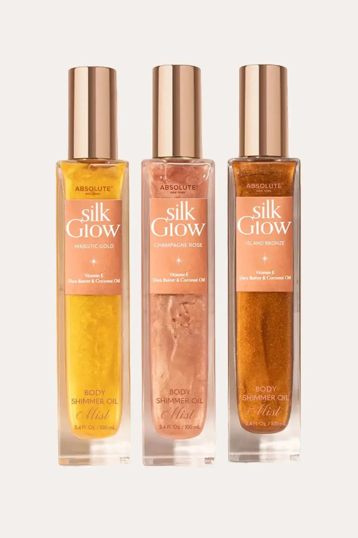 Absolute New York Silk Glow body shimmer oil mist set (Majestic Gold, Champagne Rose, Island Bronze) – Hydrating Body Shimmer MIST in three shades, 100 mL bottles on a light background.